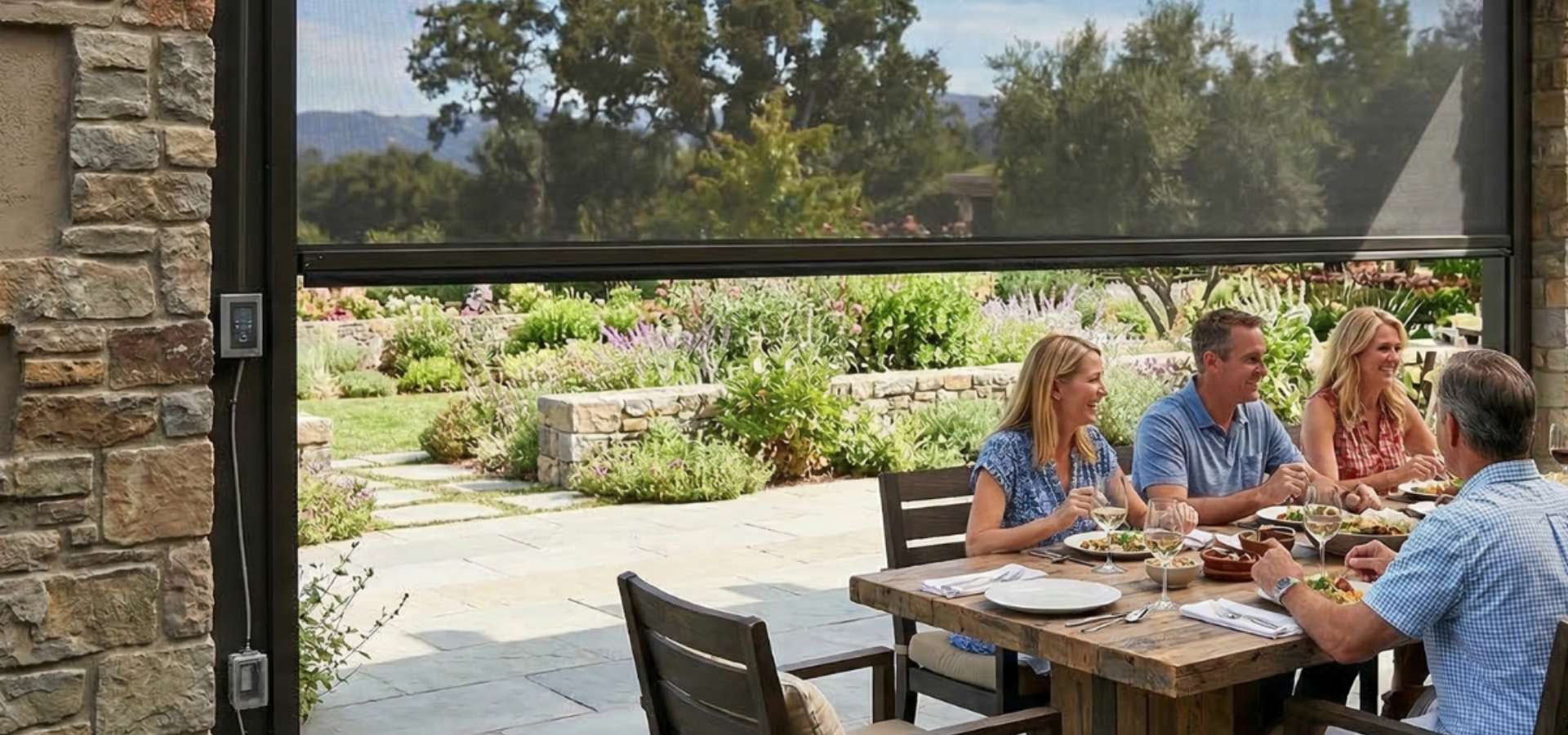 A family eats lunch at an outdoor dining area with an installed rolling sun screen.